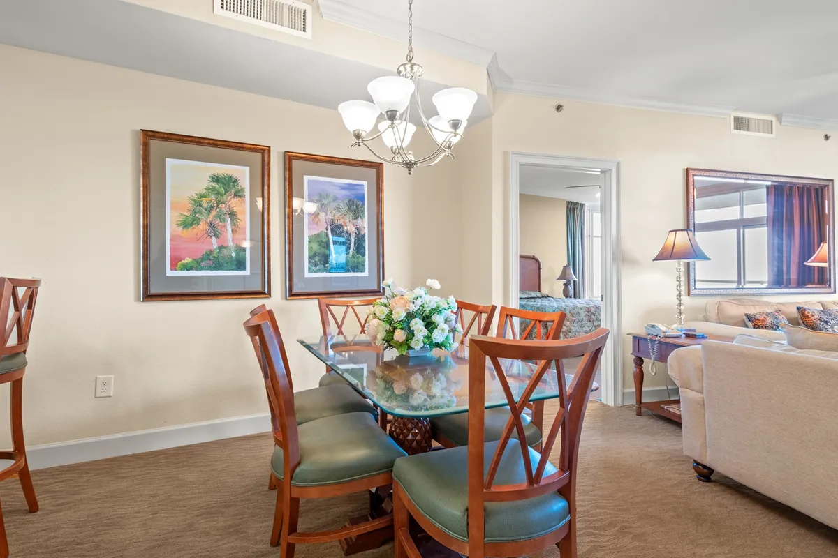 An elegant dining area is centered around a stylish table with a floral centerpiece, enhanced by a striking chandelier and tasteful wall art. The mood is inviting and relaxed, ideal for family meals and creating lasting memories.