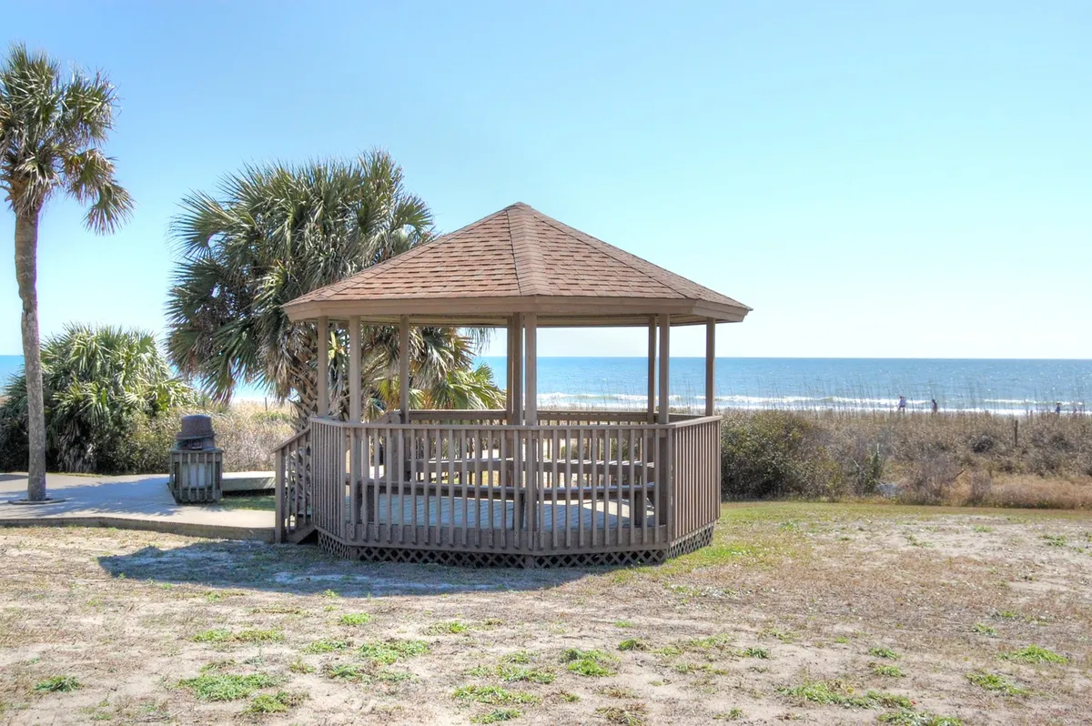 A tranquil scene featuring a charming gazebo bordered by palm trees, with unobstructed ocean views beyond—perfect for peaceful gatherings, morning coffee, or evening strolls along the beach.