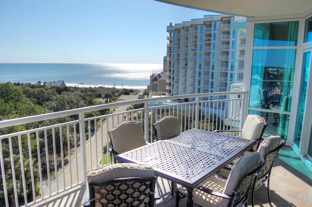 A private balcony offers tranquil seating and an outdoor table set against a sweeping ocean view. The serene setting is perfect for enjoying coffee at sunrise or sharing laughter as the waves roll in below.